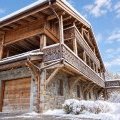 Facade chalet alpin enneigé, lumière hivernale