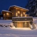 Facade chalet enneigé éclairé dans la nuit